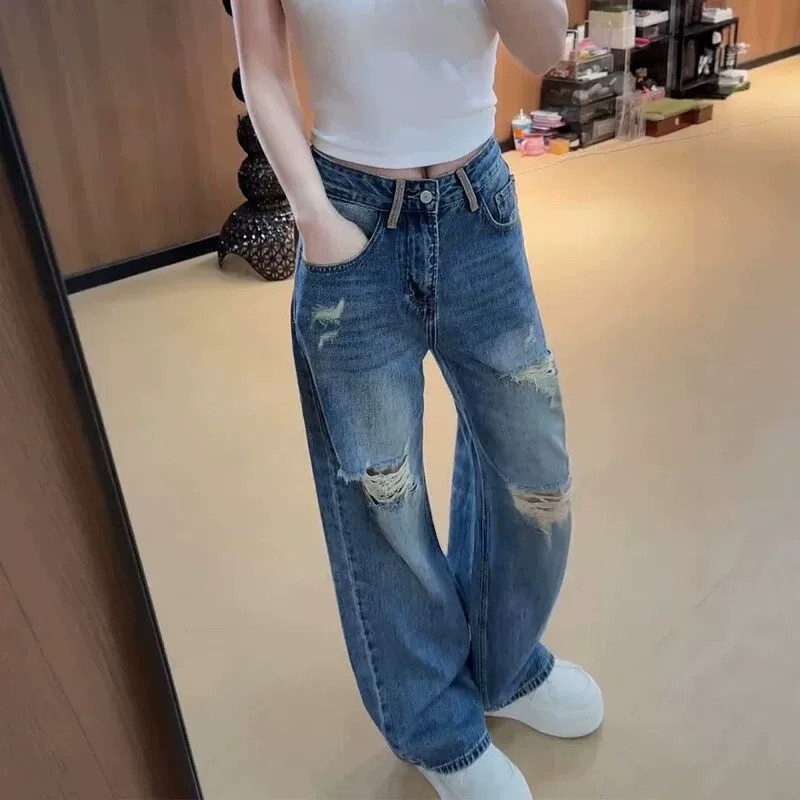 Stylish distressed jeans with a curved cut—a trendy new spring arrival featuring a high-waisted, wide-leg, floor-length silhouette.
